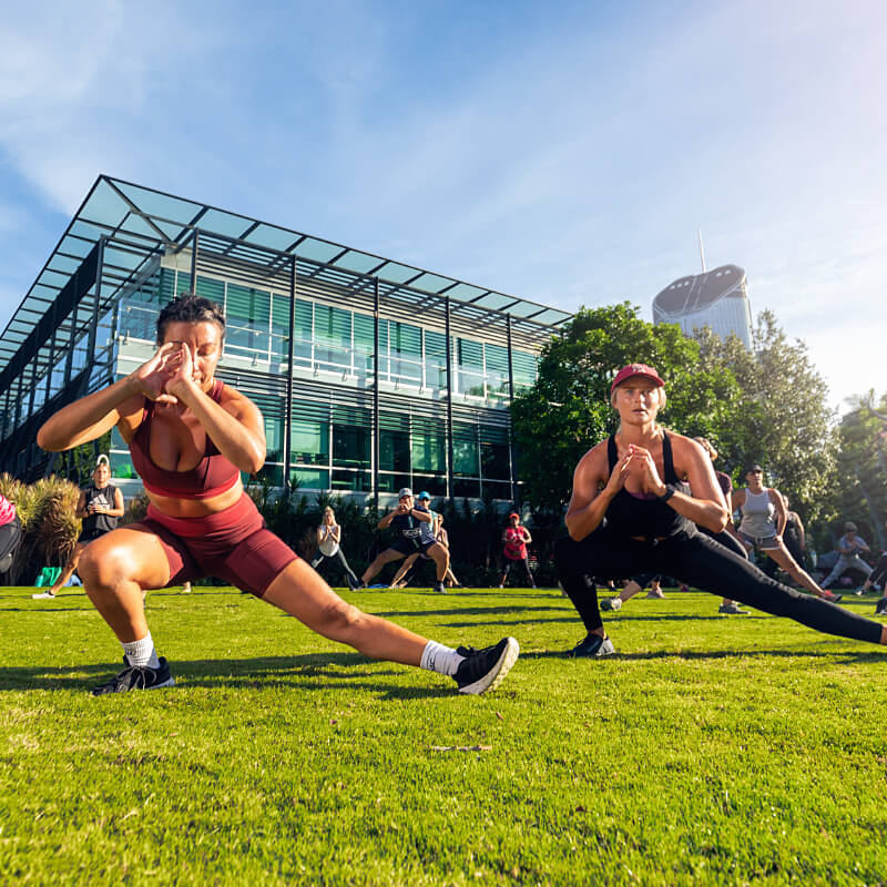 Two women doing Yoga on the lawn at South Bank Parklands